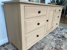 a wooden dresser sitting on top of a carpeted floor next to a planter