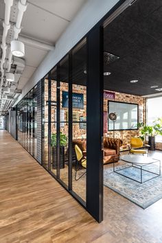 an office with glass walls and wooden floors