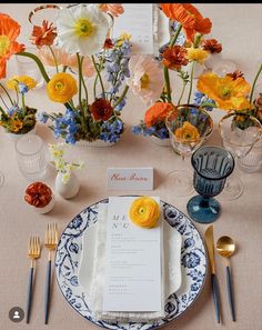 the table is set with flowers and place settings