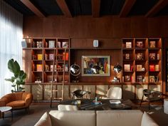 a living room filled with furniture and bookshelves next to a wall full of shelves