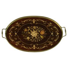 an ornately decorated wooden tray with metal handles