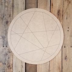 a wooden table topped with a circular cut out of paper