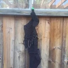 a black piece of cloth hanging on a wooden fence with chains attached to the side