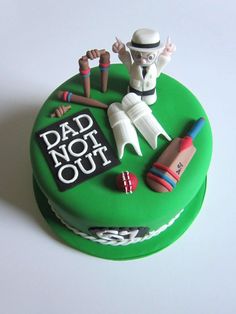 a green cake decorated with sports items and the words dad not out