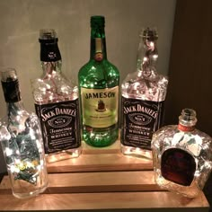 lighted liquor bottles sitting on top of a wooden table