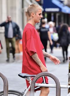 a man in red shirt standing next to a bike