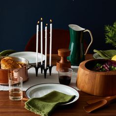 a wooden table topped with dishes and candles