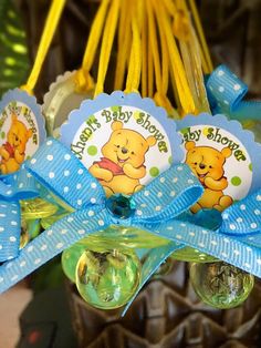 some baby shower items are hanging from a rack with blue ribbon and tags on them