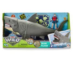 a toy shark with a man in the background