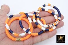 Navy Blue, Orange, White, and Square Gold Bracelets in Heishi Beads by Regina Harp Designs These bracelets are in a Navy Blue, Soft Orange, White, and Gold colors with your choice of bracelet style. They can be made with our other bead colors as well; message us if you would like to customize your bracelet.  If you need a smaller or extra large size in the bracelet, please leave us a note with your order.  To measure your wrist size you can wrap a piece of string around your wrist and mark it.  Then lay the string down flat and measure how long it is and that is your bracelet size. **SPECIFICATIONS** Measurements Approximately: Length is 6.5~7 inches; leave a note if you need a different size. Stones: 6 mm Heishi clay beads Quantity of Items: 1 bracelet unless otherwise selected Materials: Flat Circle Bead Bracelet, Heishi Bracelet College, Boy Flat Bead Bracelet, Back To School Clay Bead Bracelets, Orange Beaded Bracelets, Clay Beaded Bracelets, Tiger Team, Homemade Bracelets, Flat Beads