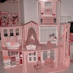 a pink doll house with furniture and accessories