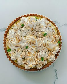 a pie with white frosting and flowers on top