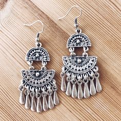 These vintage-inspired dangle earrings feature two half-moon fans filled with filigree detail, giving them captivating open spaces. Fringes on the bottom lend these chandelier earrings delightful movement and swing, adding a bohemian quality to the rustic and bright shine silver-tone finish. Shepherd's hooks keep these earrings in place. Handcrafted in Istanbul by local artisans Measurements: 5cm x 2.5cm Materials: Silver-plated zinc alloy Indian Jewelry Earrings, Boho Jewellery, Rustic Jewelry, Authentic Jewelry, Open Spaces, Boho Gifts, Bohemian Earrings, Bohemian Fashion, Local Artisans