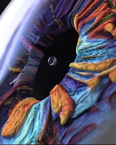 the inside of an eyeball that is made out of multicolored fabric