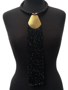 This stunning necklace has been made using authentic brass and features beautiful black beads, creating a striking piece with an ethnic feel. The pendant is delicately engraved with intricate details, and the fringe adds a touch of movement to the design. The necklace is perfect for women who love unique and eye-catching jewellery. Its African origins and cultural significance make it an ideal addition to any collection, and it will add a touch of style and elegance to any outfit.
Material: Bead African Origins, Boho Statement Necklace, Turban Headwrap, Map Necklace, Silver Bead Necklace, The Fringe, Unisex Necklace, Brass Necklace, African Jewelry