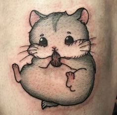 a cat tattoo on the side of a woman's thigh, with an inked image of a hamster