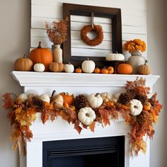 a fireplace mantle decorated with pumpkins and other autumn decorations