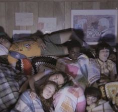 a group of people laying on top of a bed in the middle of a room