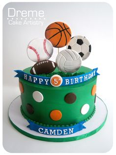 a birthday cake decorated with sports balls and ribbons