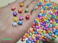 a person's hand is full of multicolored stars