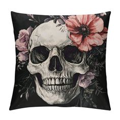 a pillow with a skull and flowers on the front, it has a black background