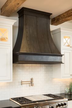 a stove top oven sitting inside of a kitchen next to white cabinets and counter tops