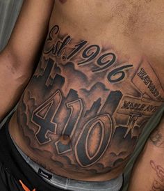 a man's stomach with the number forty and his name tattooed on it in black ink