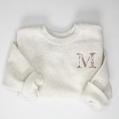 Oatmeal colored custom embroidered toddler and kids crewneck sweatshirt. Floral initial design.  Please reach out for bulk orders on sold out sizes!  Browse my Etsy shop for more sweatshirt options. Please message me with any personalized design requests :)  Long-sleeved sweatshirts are very soft. 60% cotton, 40% polyester fleece. Coverstitched ribbed collar, coverstitched shoulder and armholes, coverstitched cuffs and bottom band.  HOW TO ORDER:  Please select size and letter from the drop down Cream Long Sleeve Sweater With Letter Embroidery, White Monogram Cotton Sweatshirt, Cozy Long Sleeve Sweatshirt With Letter Embroidery, Personalized Cotton Sweatshirt For Fall, Personalized Crew Neck Sweatshirt For Fall, Cotton Monogram Sweatshirt, Cotton Monogram Long Sleeve Sweatshirt, Custom Embroidered Sweatshirt For Winter Loungewear, Winter Custom Embroidery Sweatshirt For Loungewear