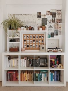 a bookshelf filled with lots of books next to a potted plant on top of it