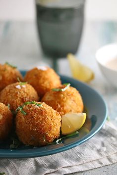 some food is on a blue plate with lemon wedges