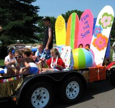 a group of people riding in the back of a truck with surfboards on it