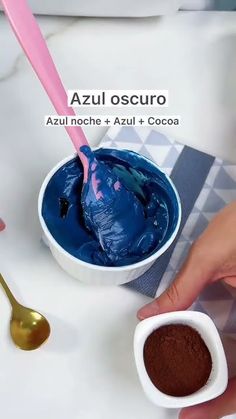 a hand holding a spoon and scooping chocolate into a bowl with blue icing