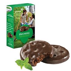 two chocolate covered donuts next to a box of minty mints on a white background