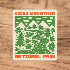 the rocky mountain national park sticker is shown on a wooden surface with wood grain