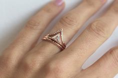 a close up of a person's hand with a diamond ring on their finger