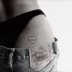 a woman's stomach with a small heart tattoo on it