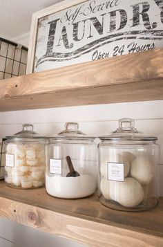 three glass jars filled with white balls on top of a shelf