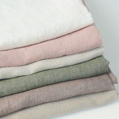 four different colored linens stacked on top of each other in various sizes and colors