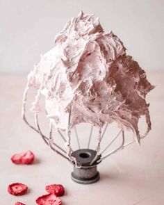 a whisk filled with whipped cream and raspberries on top of a table