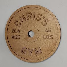 a wooden disk with the words gym engraved on it's side and an inscription that reads, christ's 24 kgs 45lbs gym