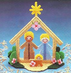 a cross stitch nativity ornament with three people and a baby jesus in the manger