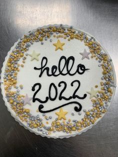 a birthday cake with the words hello 2012 written in black and gold on it's frosting