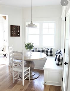 a dining room table and bench in front of a window