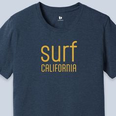 Surf California T-Shirt available in Navy Blue Heather color  This classic unisex jersey short sleeve tee fits like a well-loved favorite. Soft cotton and quality print make users fall in love with it over and over again. These t-shirts have-ribbed knit collars to bolster shaping. The shoulders are tapered for a better fit over time. Dual side seams hold the garment's shape for longer.  .: This t-shirt comes with a lightweight fabric (4.2 oz/yd² (142 g/m that is easy to layer thanks to its breathability and the perfect choice for both active and leisure wear. The 100% Airlume combed and ring-spun cotton feels soft to the touch. .: The retail fit that is perfect for casual and semi-formal settings. Meanwhile, the crew neckline adds a timeless, classic touch and a neat appearance that is per Cotton Short Sleeve Surfing T-shirt, Short Sleeve Cotton T-shirt For Surfing, Cotton Short Sleeve T-shirt For Surfing, Short Sleeve Screen Print Tops For Surfing, Casual Camp Shirt With Letter Print, Blue Short Sleeve Tops For Surfing, Casual Short Sleeve Camp Shirt With Letter Print, Casual Crew Shirt With Letter Print, Casual Crew Neck Shirt With Letter Print