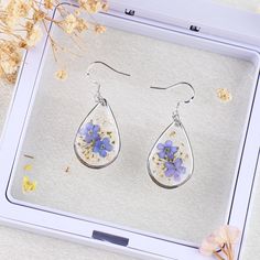 925 Sterling Silver Forget Me Not Flower Earrings | Real Pressed Flower Earrings | Handmade Floral Earrings for Women | Dangle Drop Earrings | Non-allergenic 🌸【Size】: 1 * 1.6 inches 🌸Introducing our exquisite 925 Sterling Silver Forget Me Not Flower Earrings. These stunning and unique floral earrings are meticulously handcrafted with love, adding a touch of natural beauty to your jewelry collection. Made from real pressed forget-me-not flowers, these dangle drop earrings beautifully display the delicate petals and vibrant blue hues of the forget-me-not blossoms. 🌸Highlights: 1. Handmade with Love: Each pair of these earrings is crafted by skilled artisans with the utmost care, ensuring a truly one-of-a-kind piece of jewelry. 2. Real Pressed Flowers: We select and preserve genuine forget Silver Birth Flower Drop Earrings, Sterling Silver Drop Earrings With Birth Flower, Sterling Silver Birth Flower Drop Earrings, Silver Pressed Flowers Drop Earrings, Silver Birth Flower Earrings As Gift For Her, Elegant Silver Earrings With Pressed Flowers, Silver Pressed Flowers Earrings For Gift, Silver Round Earrings With Pressed Flowers, Silver Dangle Earrings With Birth Flower