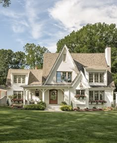 a large white house sitting on top of a lush green field