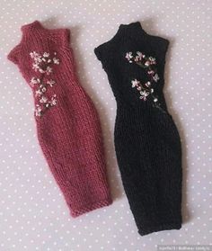 two knitted dresses sitting on top of a polka dot table