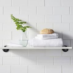 a shelf with towels and a plant on it