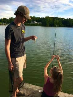 a man and woman standing on a dock fishing