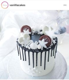 a white and black frosted cake with chocolate decorations